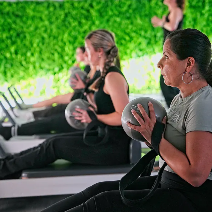 Members holding Pilates balls during class